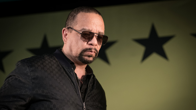 Ice-T performing in front of a wall of large, military-style stars