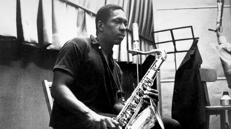 John Coltrane looking pensive holding an alto saxophone