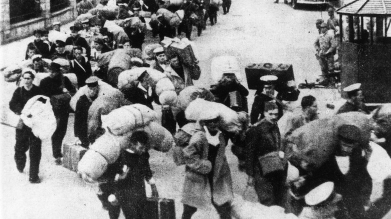 White prisoners march into Japanese prison camp