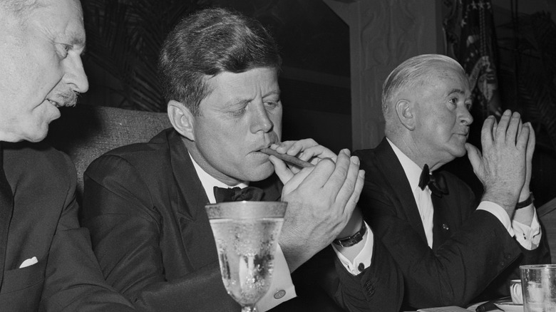President Kennedy lights a cigar