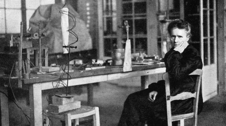 marie curie sitting at lab table