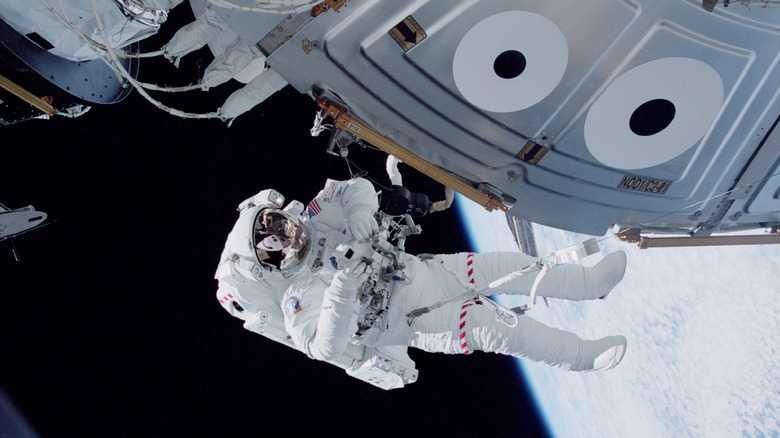 Astronaut in bulky white suit on  spacewalk