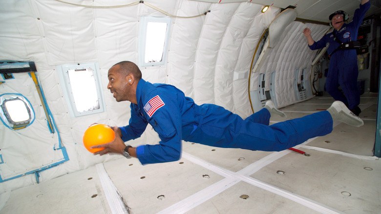 floating astronaut holding a ball