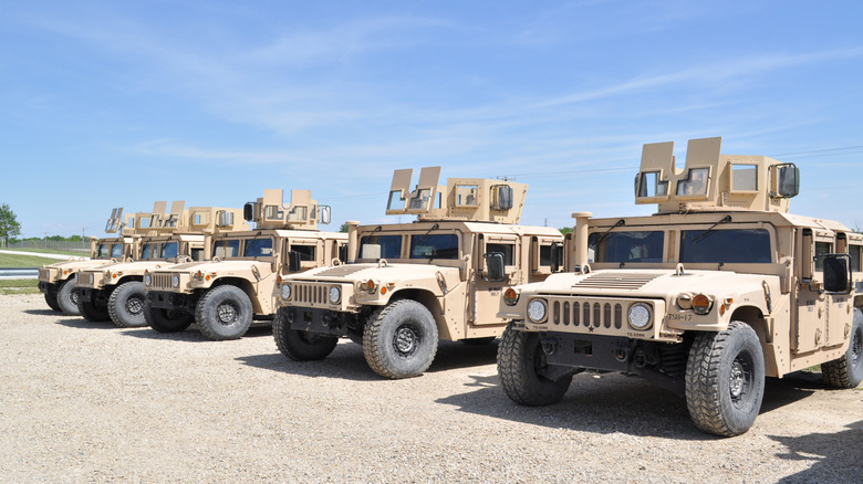sand camo us military vehicles against blue sky