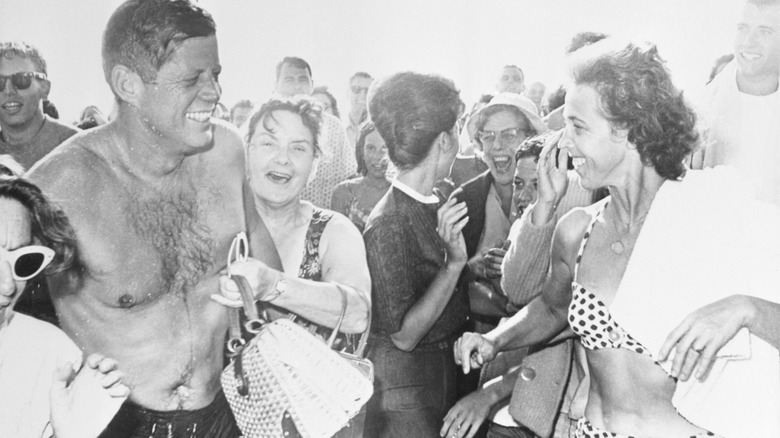 JFK in swim clothes surrounded by crowd