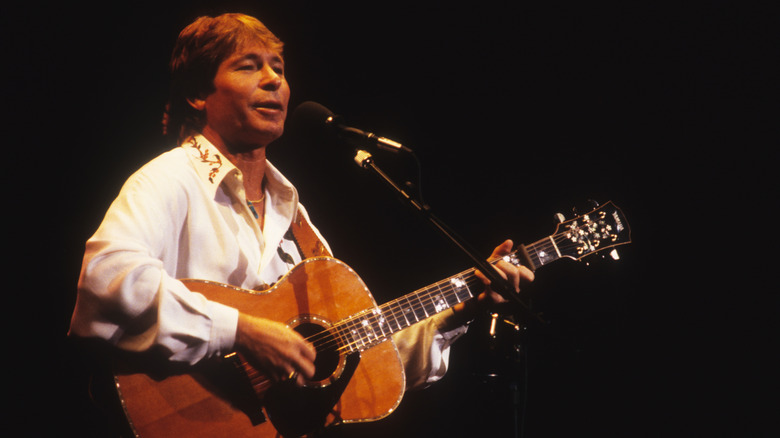 John Denver with guitar and mic
