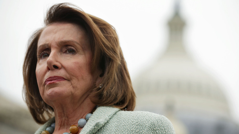 Nancy Pelosi stands before the Capitol