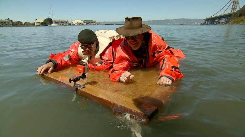 Jamie and Adam on mock Titanic door frame in dry suits.