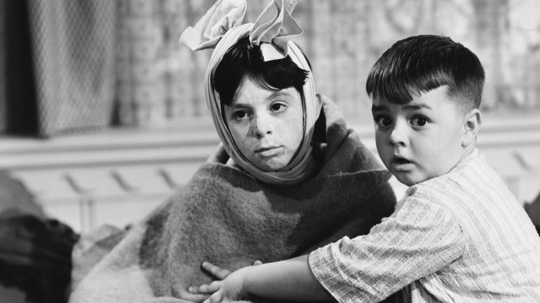 Carl Switzer as child wrapped in blanket and head scarf sat with child costar
