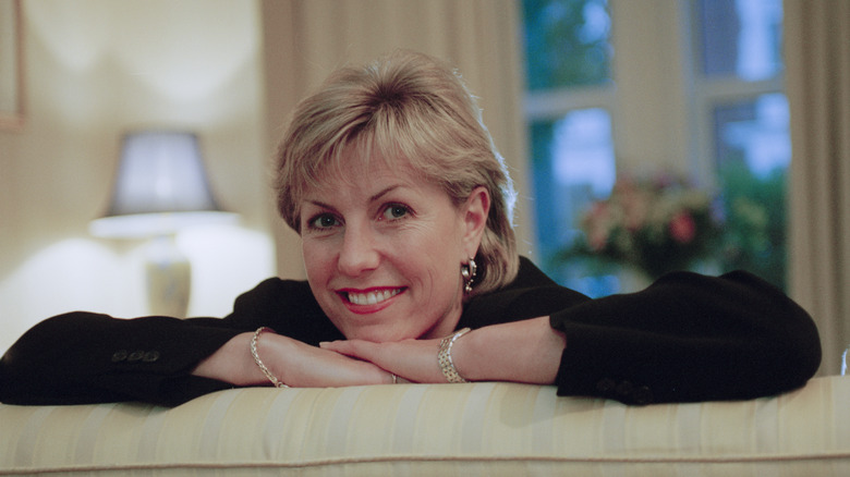 jill dando smiling leaning over back of sofa