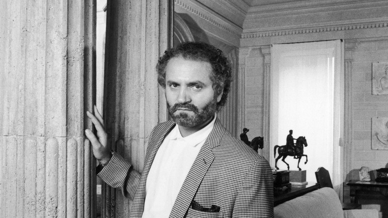 Beared Versace posing indoors in casual suit