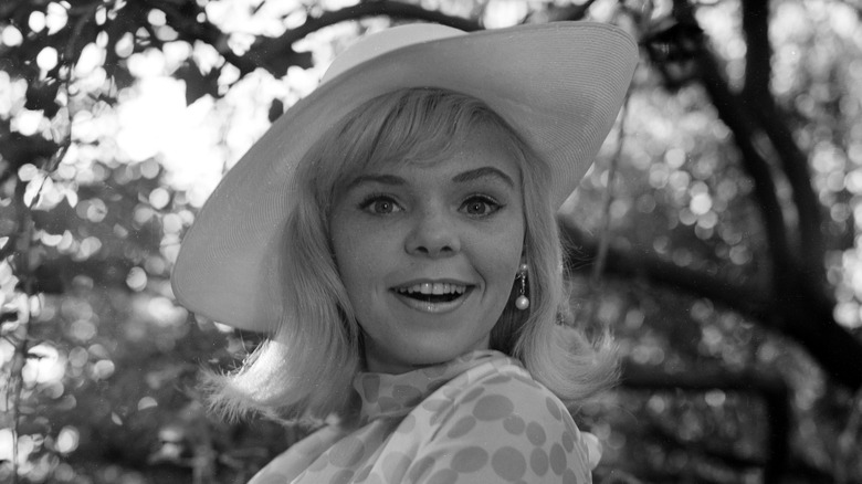 jenny maxwell smiling in a wide hat with trees in background