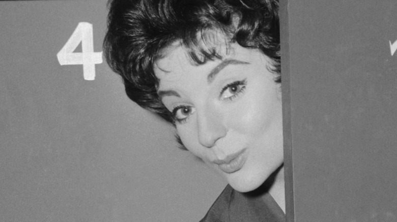 Karyn Kupcinet lips pursed peeking from behind a door