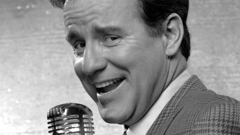 phil hartman in suit smiling with microphone