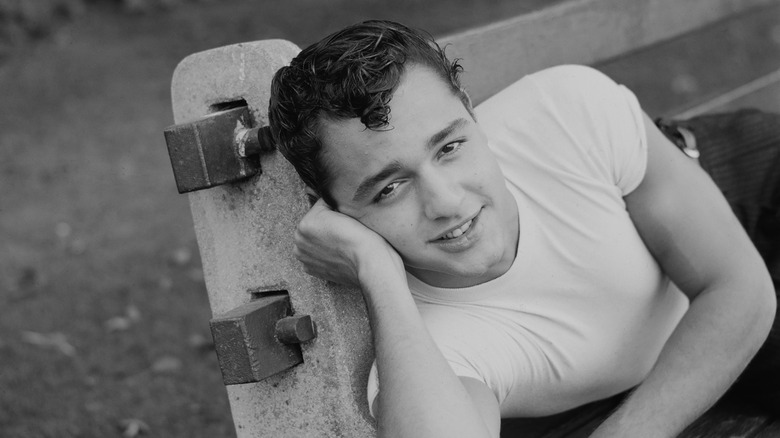 sal mineo smiling laying on park bench