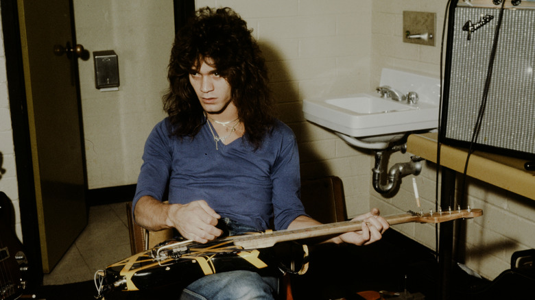 Eddie Van Halen playing his guitar in a locker room