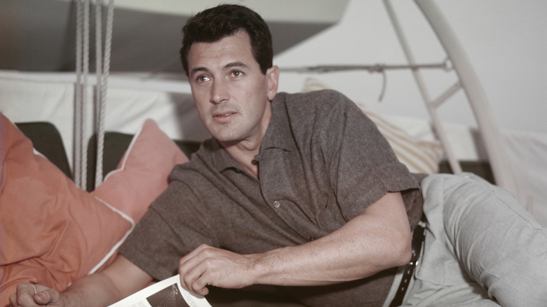 Rock Hudson looks up from reading