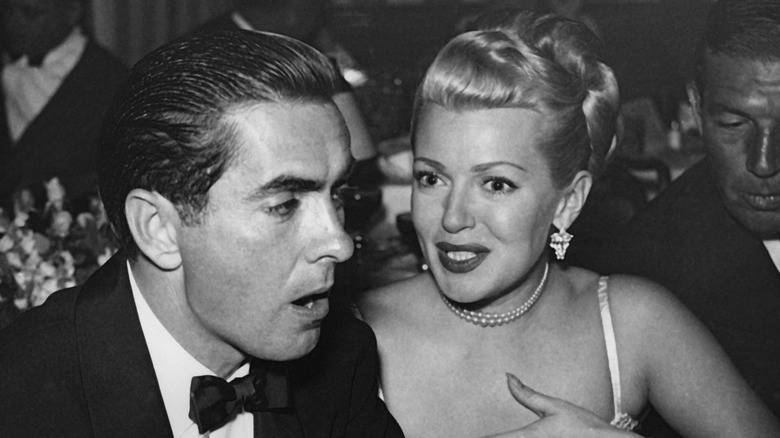 Tyrone Power and Lana Turner talking at event