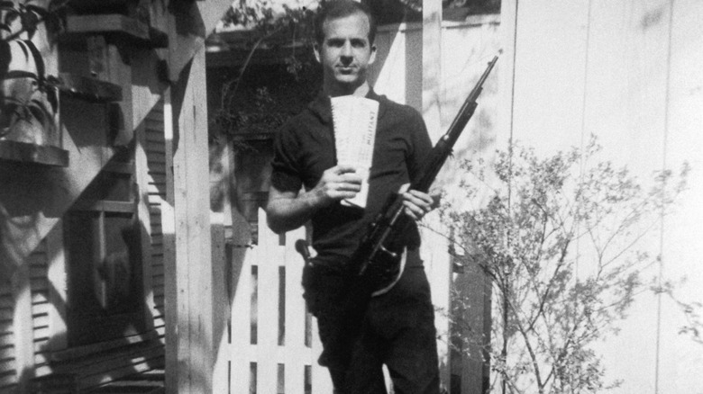 Lee Harvey Oswald holding a rifle in his backyard
