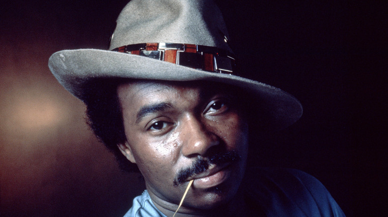 Van McCoy with tilted hat and chewing on hay
