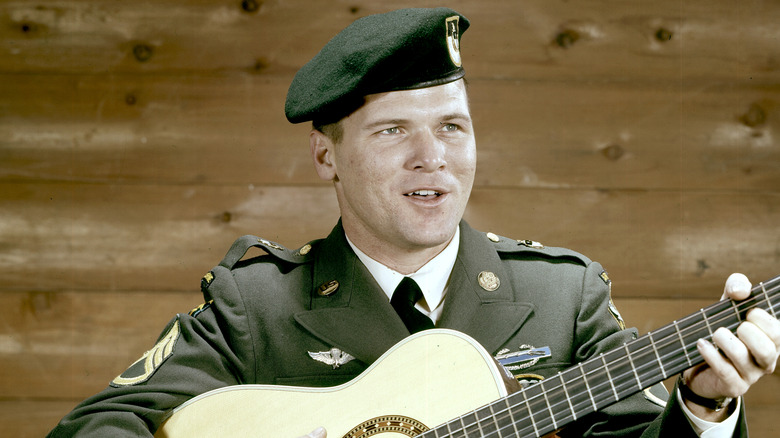 Ssgt. Barry Sadler singing and playing guitar in uniform