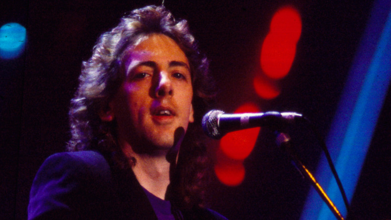 Randy VanWarmer singing into microphone onstage