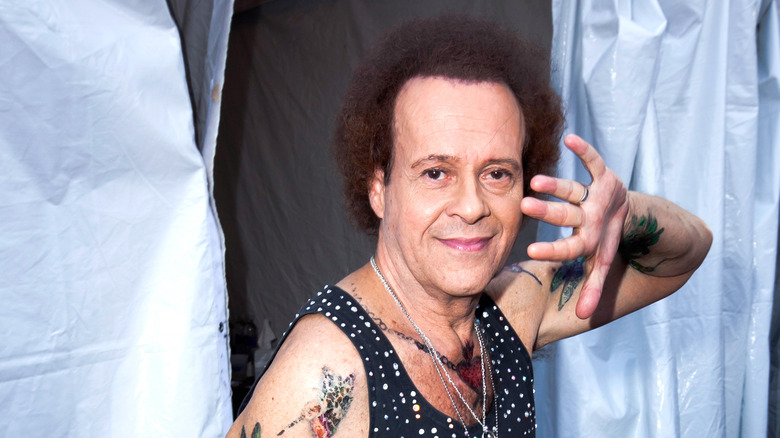 Richard Simmons waving hand across his face
