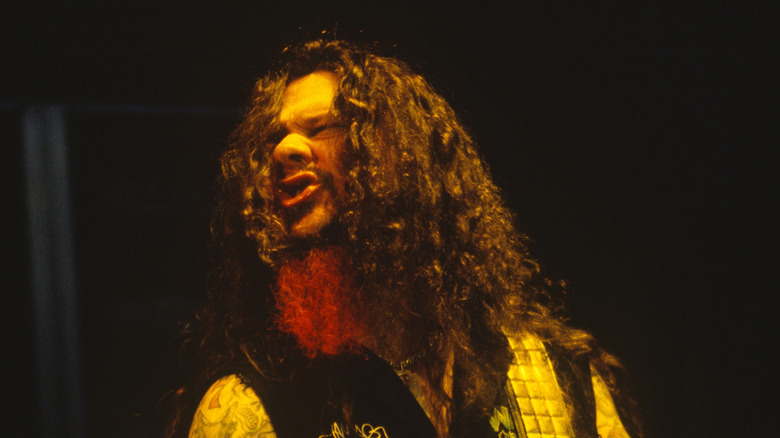 Dimebag Darrell sneering on stage and playing guitar