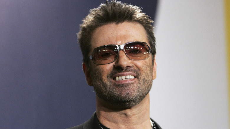 George Michael smiling in dark glasses