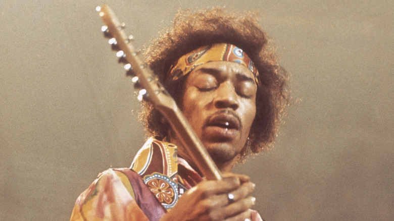 Jimi Hendrix eyes closed playing guitar on stage