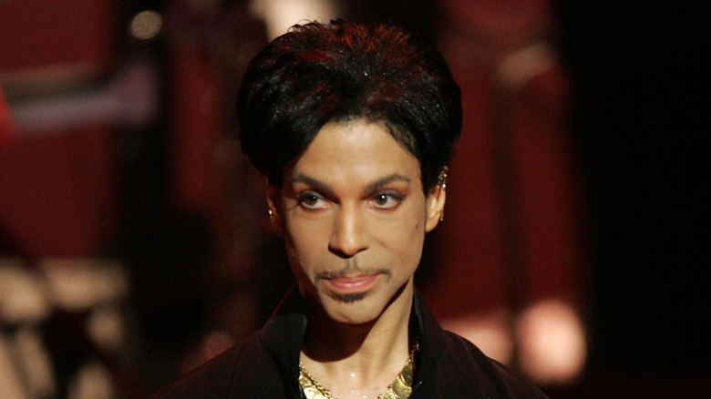 Prince on stage smirking and looking away