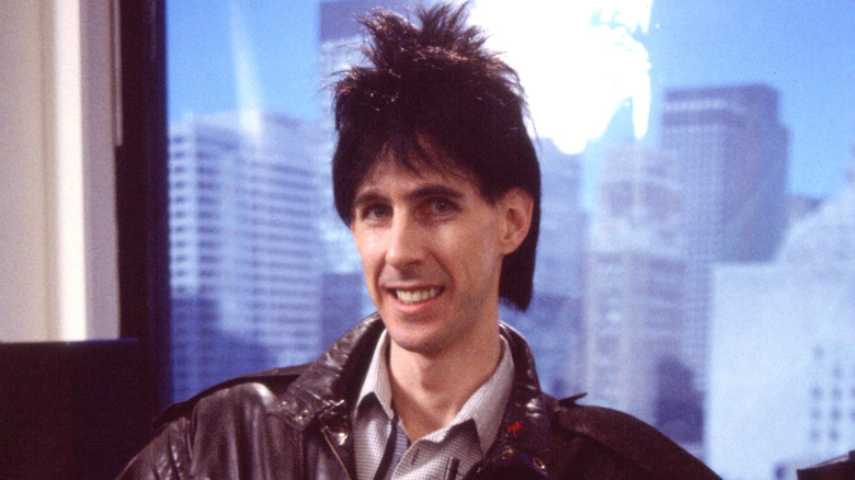 Ric Ocasek smiling in front of window