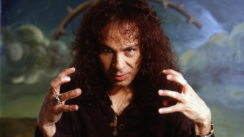 Ronnie James Dio holding hands up and staring