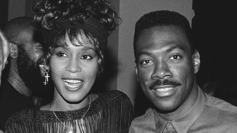 Whitney Houston standing close to Eddie Murphy
