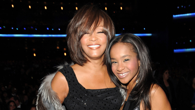 Whitney Houston snuggling Bobbi Kristina Brown and smiling