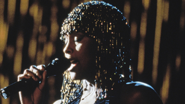 Whitney Houston singing in a still from The Bodyguard
