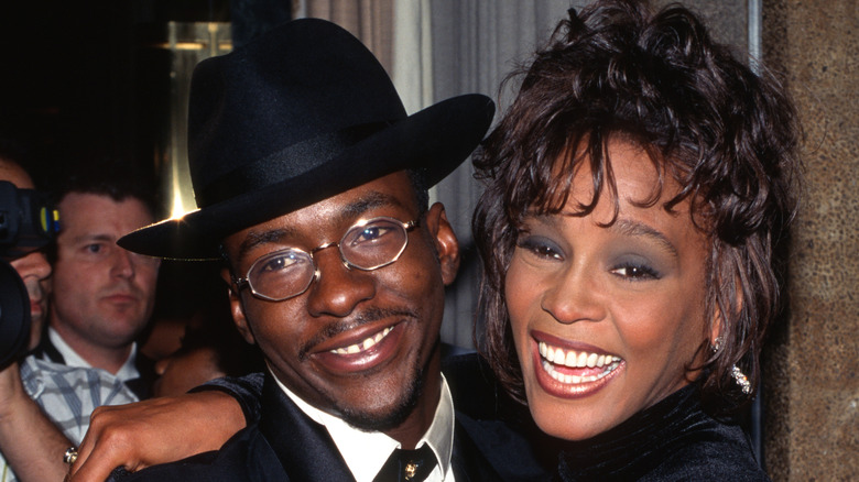 Bobby Brown and Whitney Houston standing close and smiling