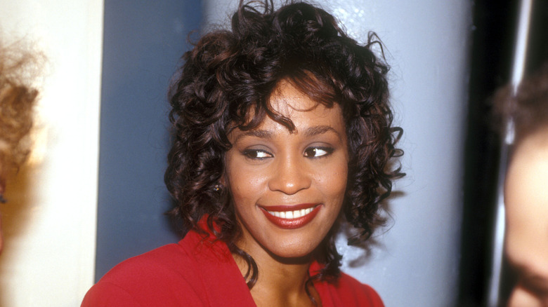 Whitney Houston smiling and looking off toe side