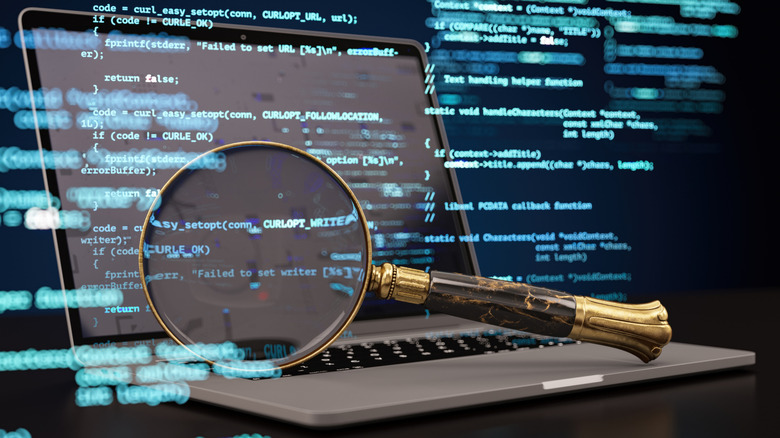 Laptop with magnifying glass and data code