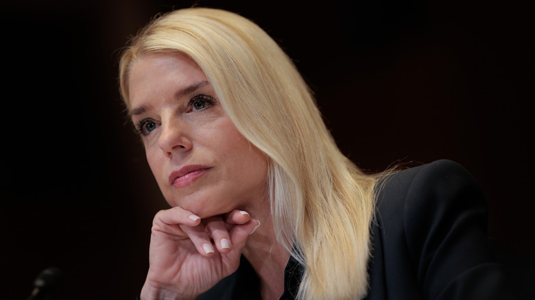 Pam Bondi black background listening to something