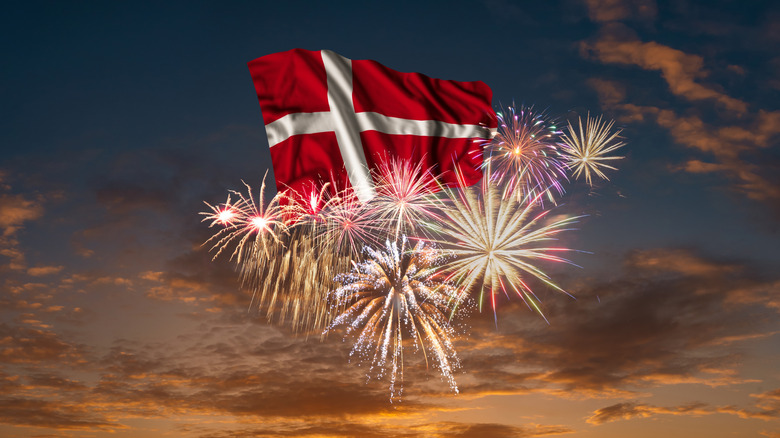 Flag of Denmark in the sky with fireworks