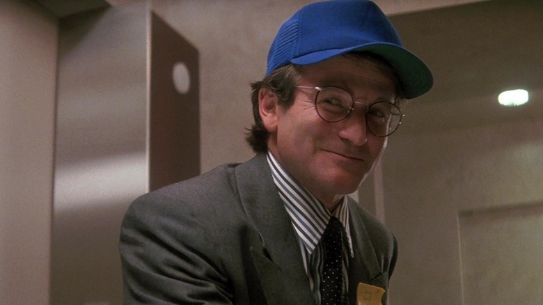 Robin Williams' Peter Banning wearing a blue cap and smiling in Hook