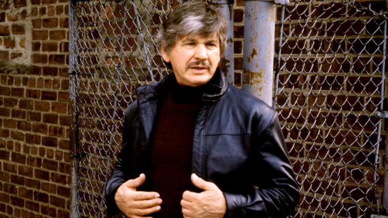 Charles Bronson's Paul Kersey adjusting his jacket in Death Wish 3
