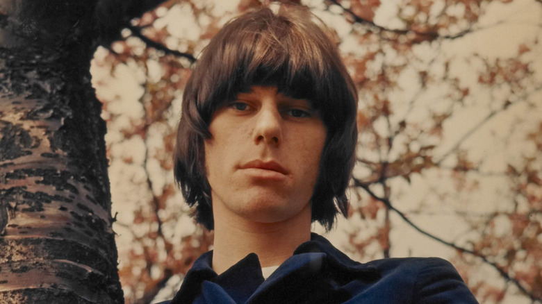 Jeff Beck standing by a tree