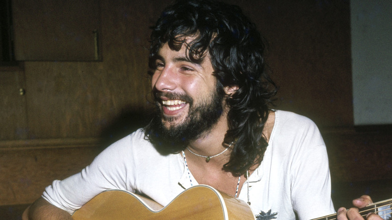Cat Stevens playing guitar and looking away