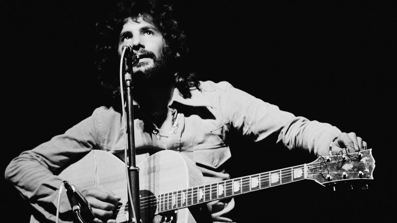 Cat Stevens playing guitar on stage