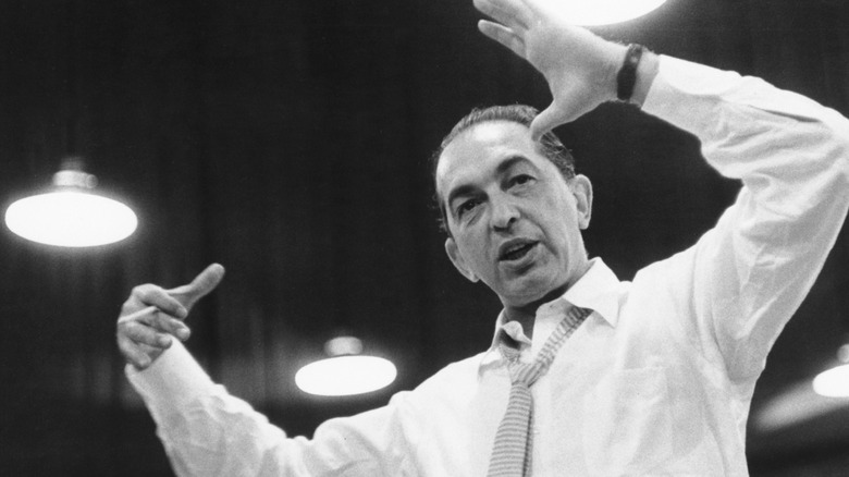 Percy Faith in sunglasses conducting outside