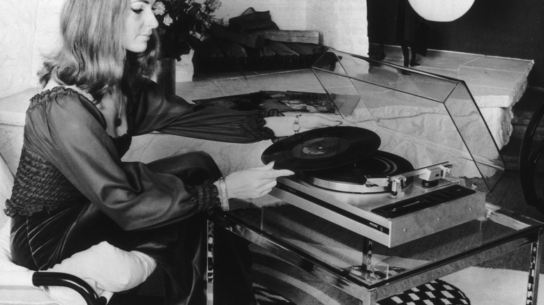 woman listening to an lp on a record player 1970s