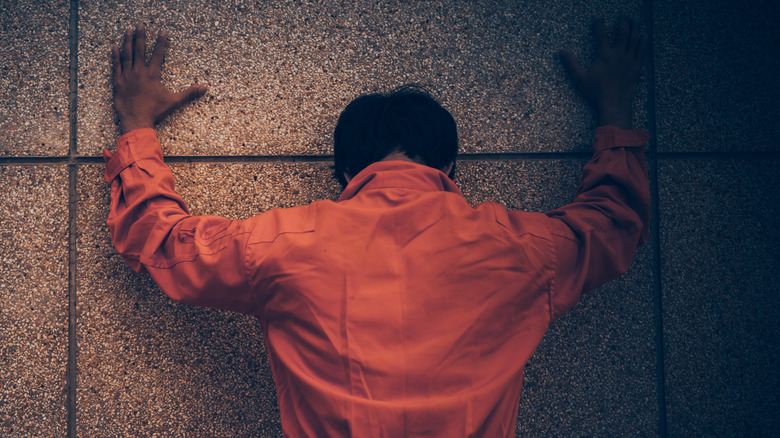 Man with hands against wall