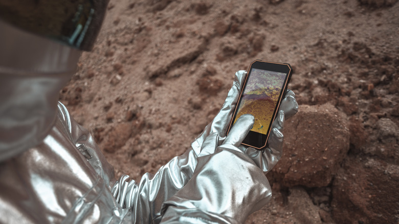 astronaut in helmet using smartphone